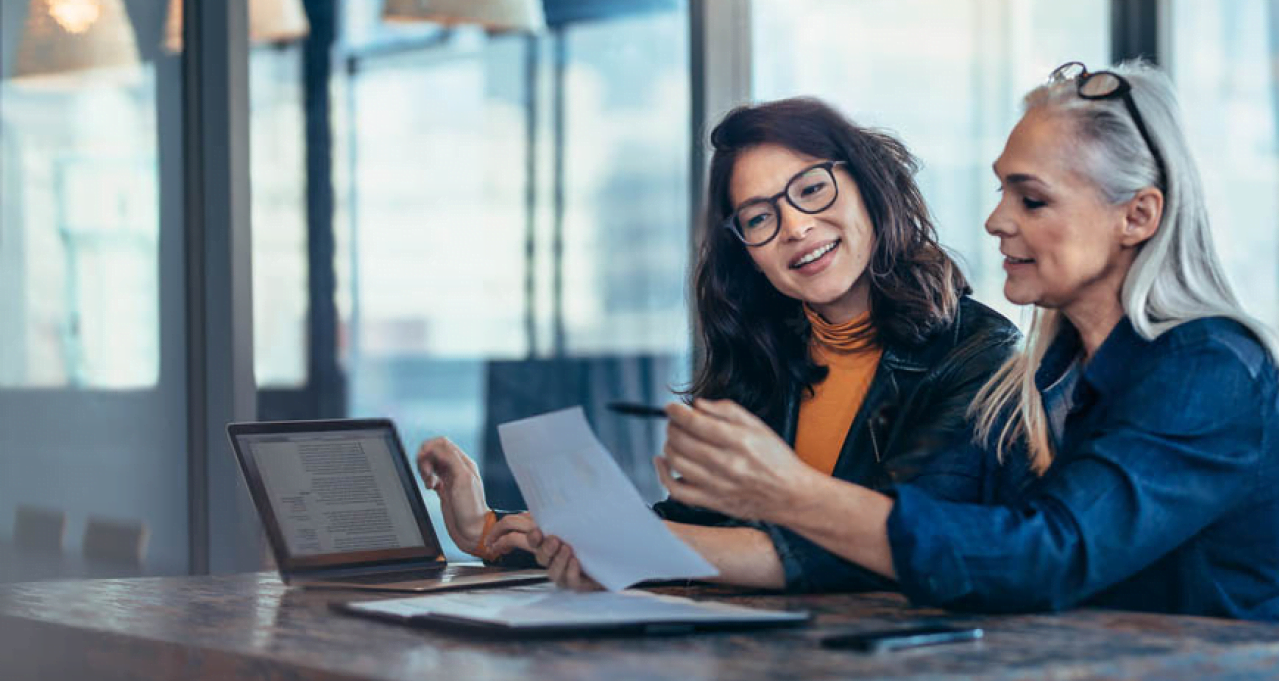 Female colleagues discussing client paperwork | Alliant Private Client