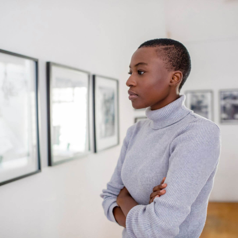Woman looking at fine art on the wall | Alliant Private Client