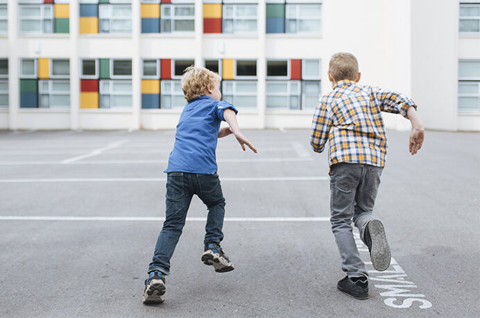2 kids running on the blacktop at school | Alliant Private Client