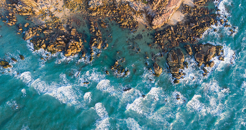 Alliant Private Client | Building Resilience in Today's Insurance Market | Aerial Drone View Of Wave Crashing On Rocky Coast 800x423