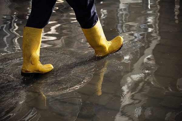 Yellow rainboots walking through flooded road | Alliant Private Client