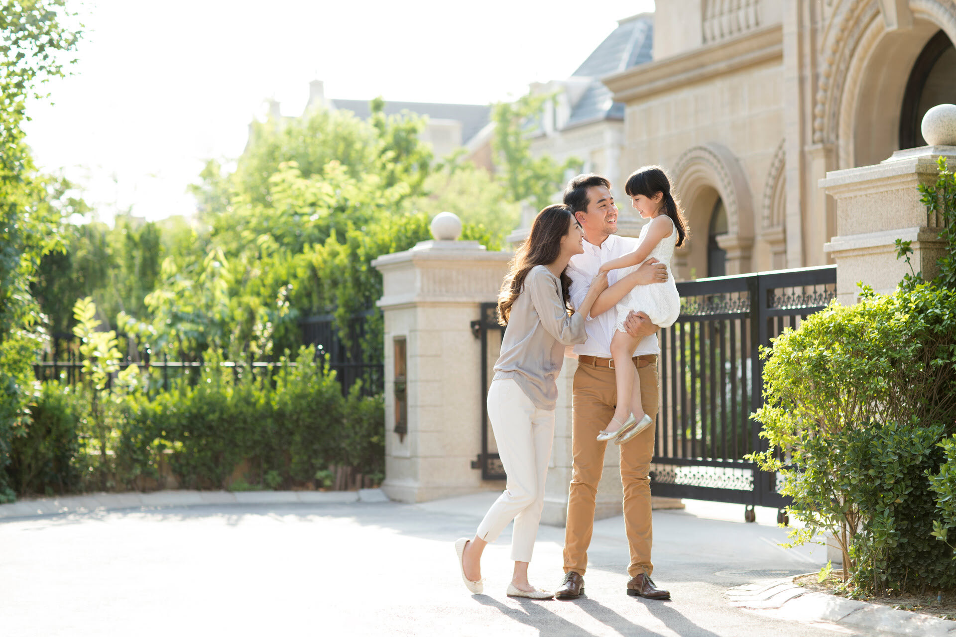 Happy family in front of affluent home | Alliant Private Client